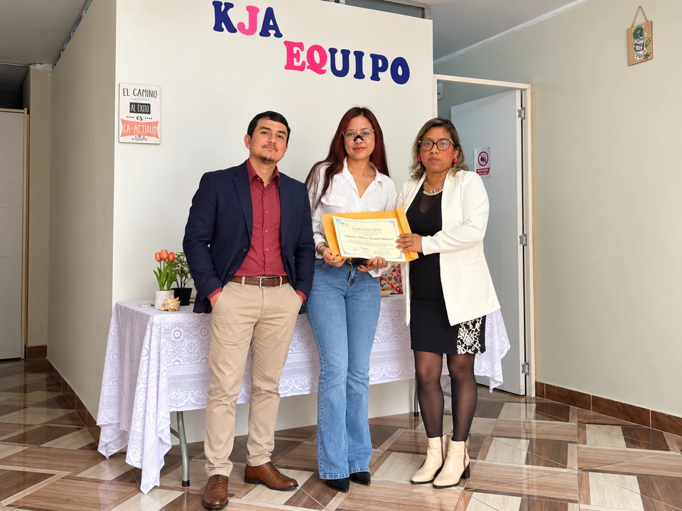 Integrante de KJA con su reconocimiento, acompañada por el equipo